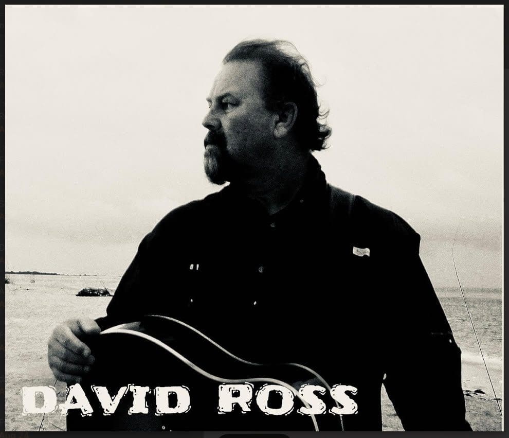 Black and white portrait of a man playing guitar.