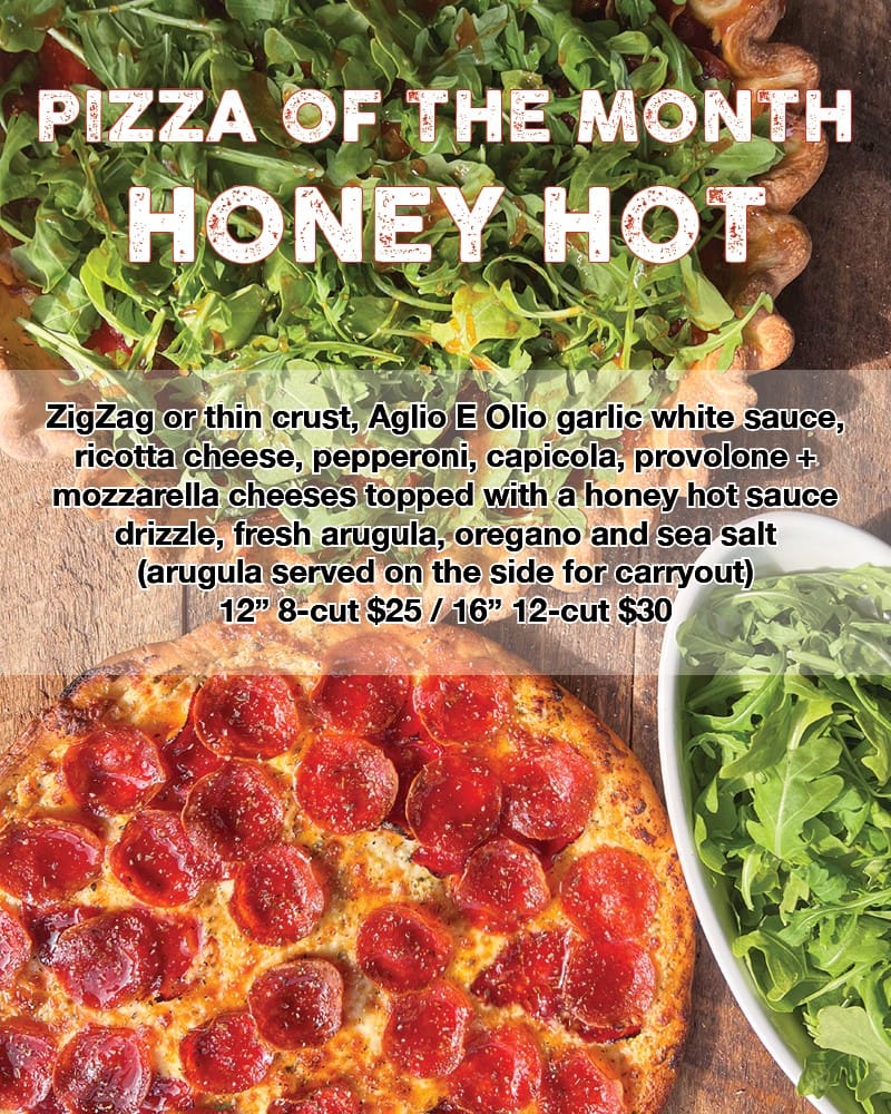 Honey hot pizza topped with fresh arugula.